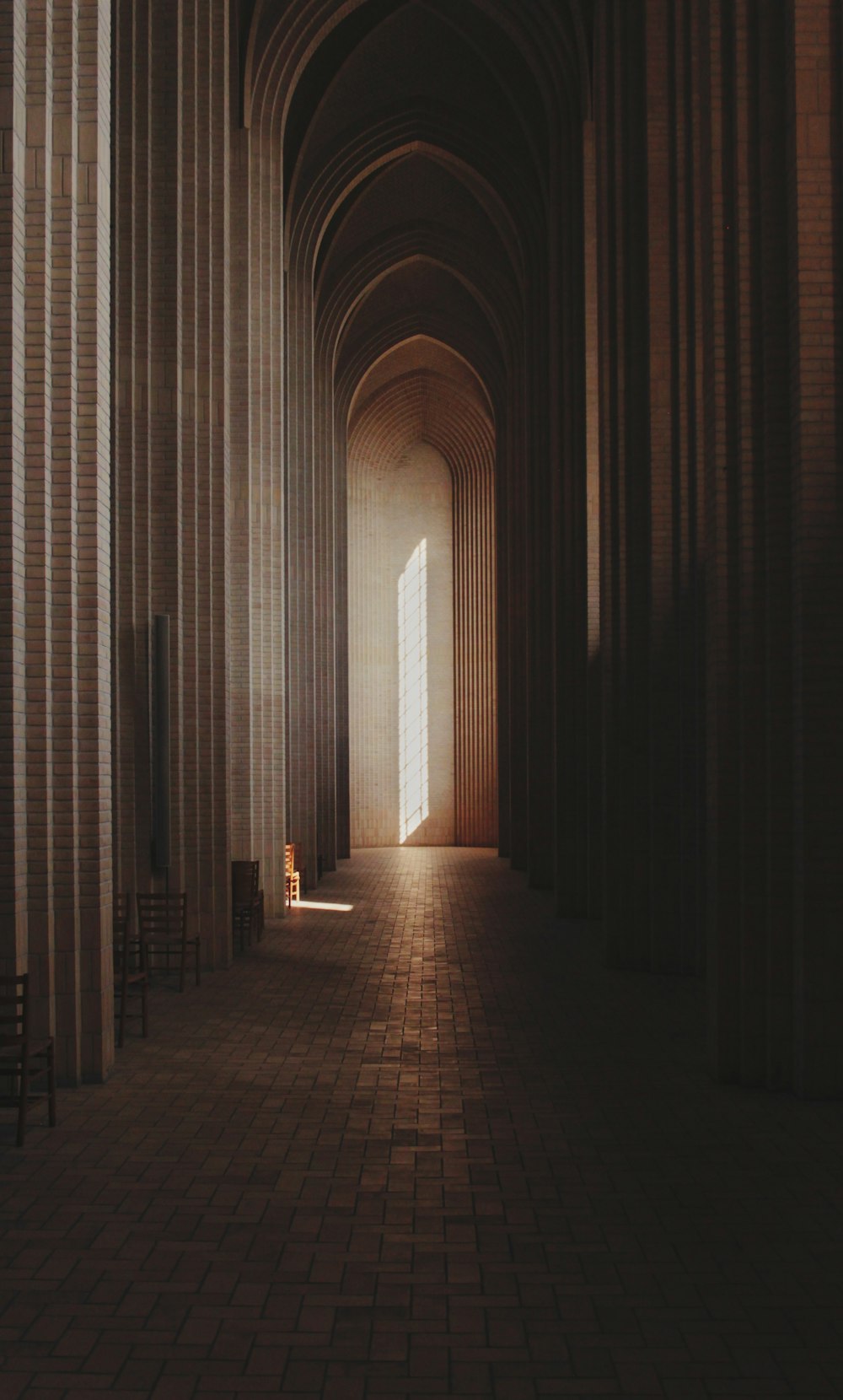 a long hallway with rows of columns and chairs