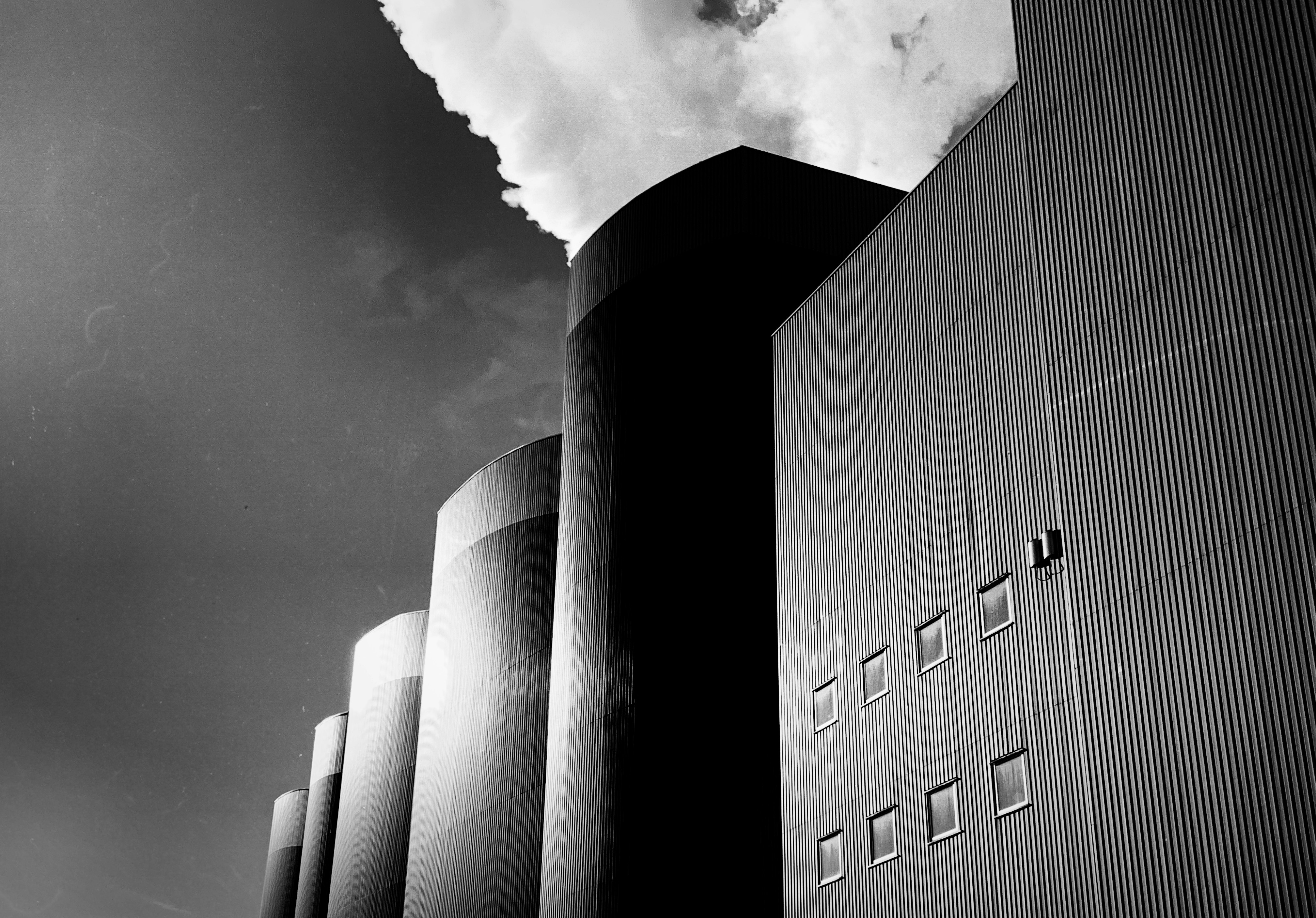 a black and white photo of a building with smoke coming out of it