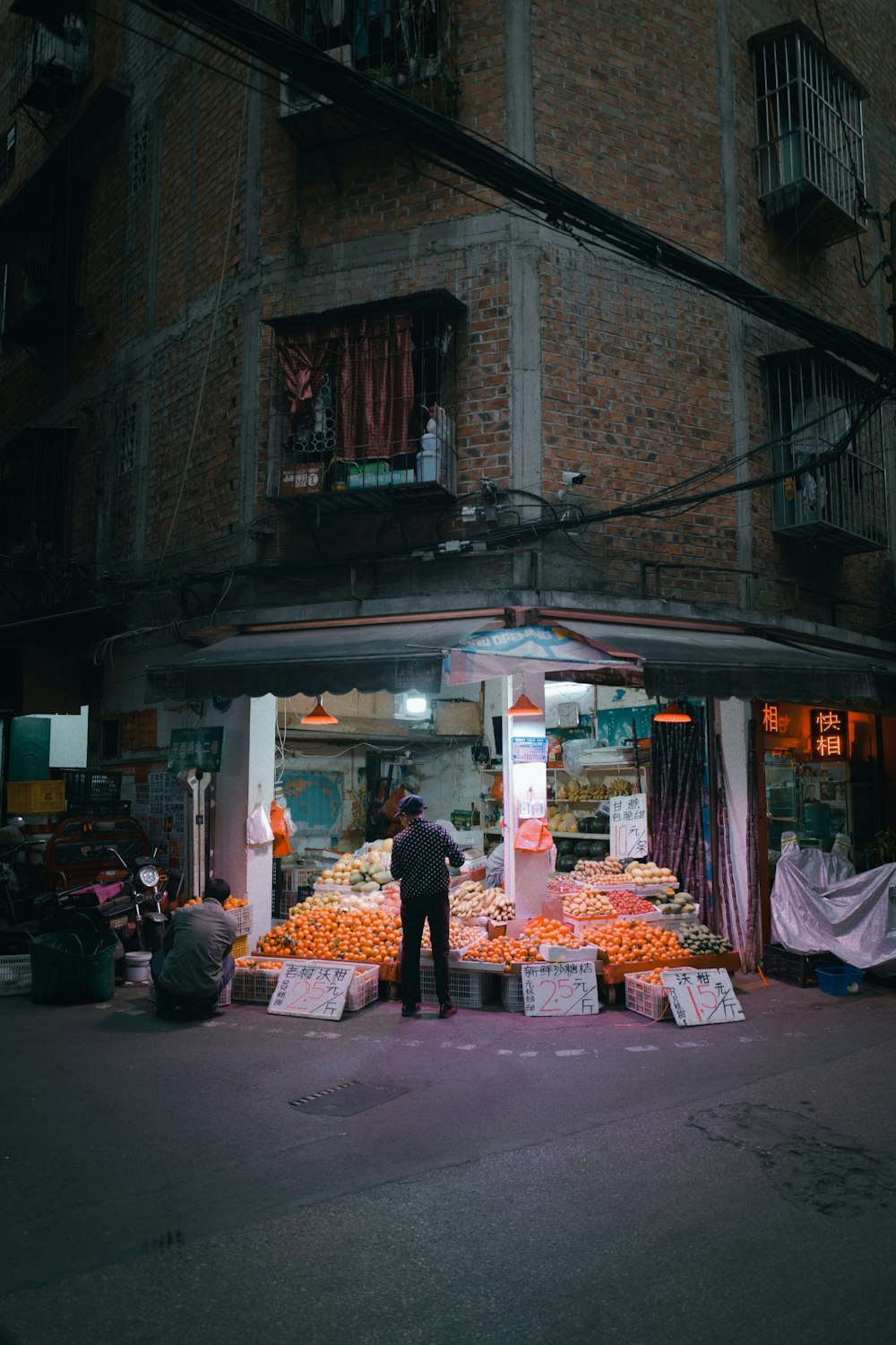 a man standing in front of a store filled with oranges