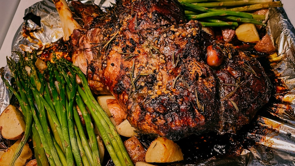 a close up of a plate of food with meat and asparagus