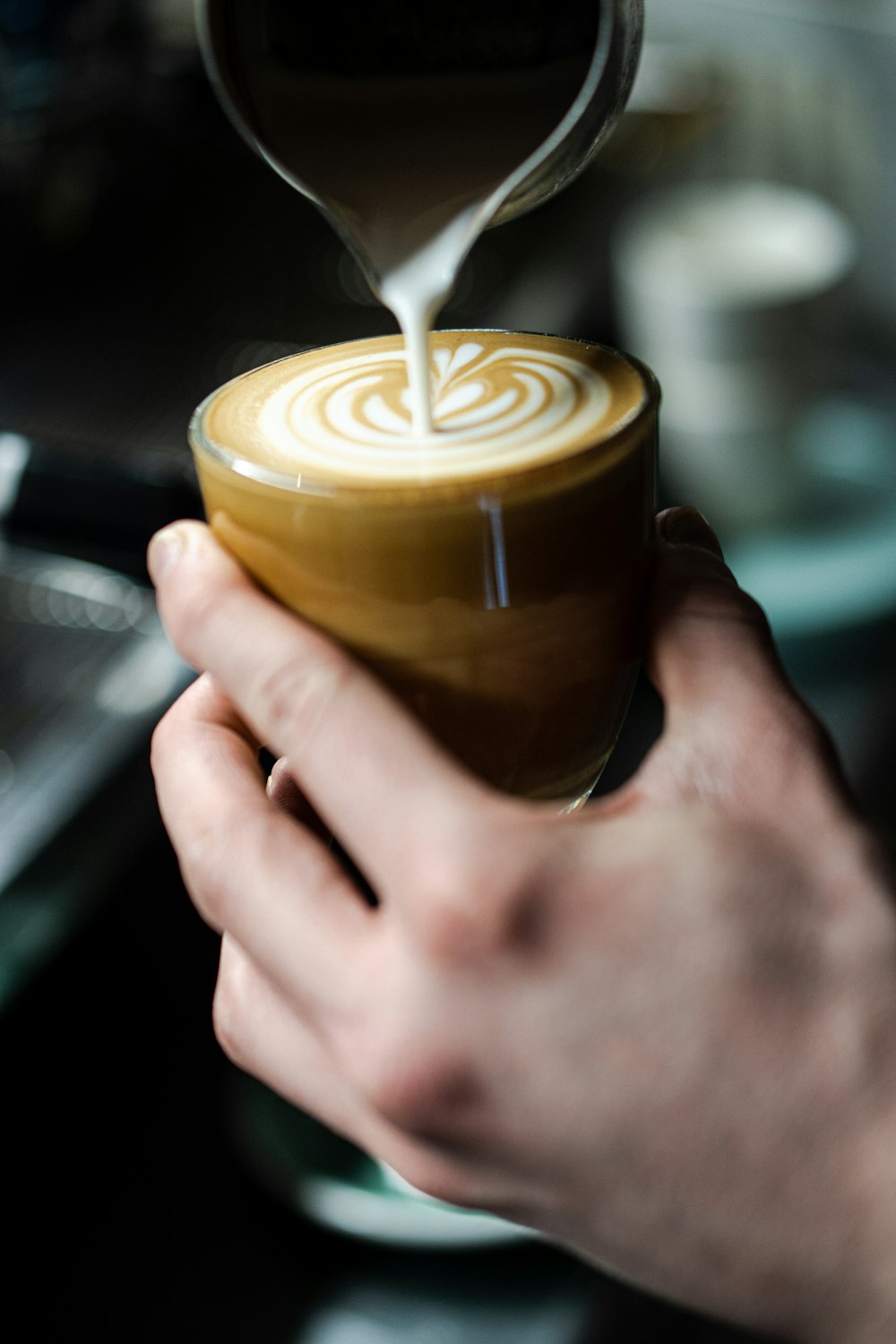 a person holding a cup of coffee in their hand