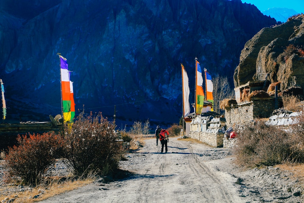 Un par de personas caminando por un camino de tierra