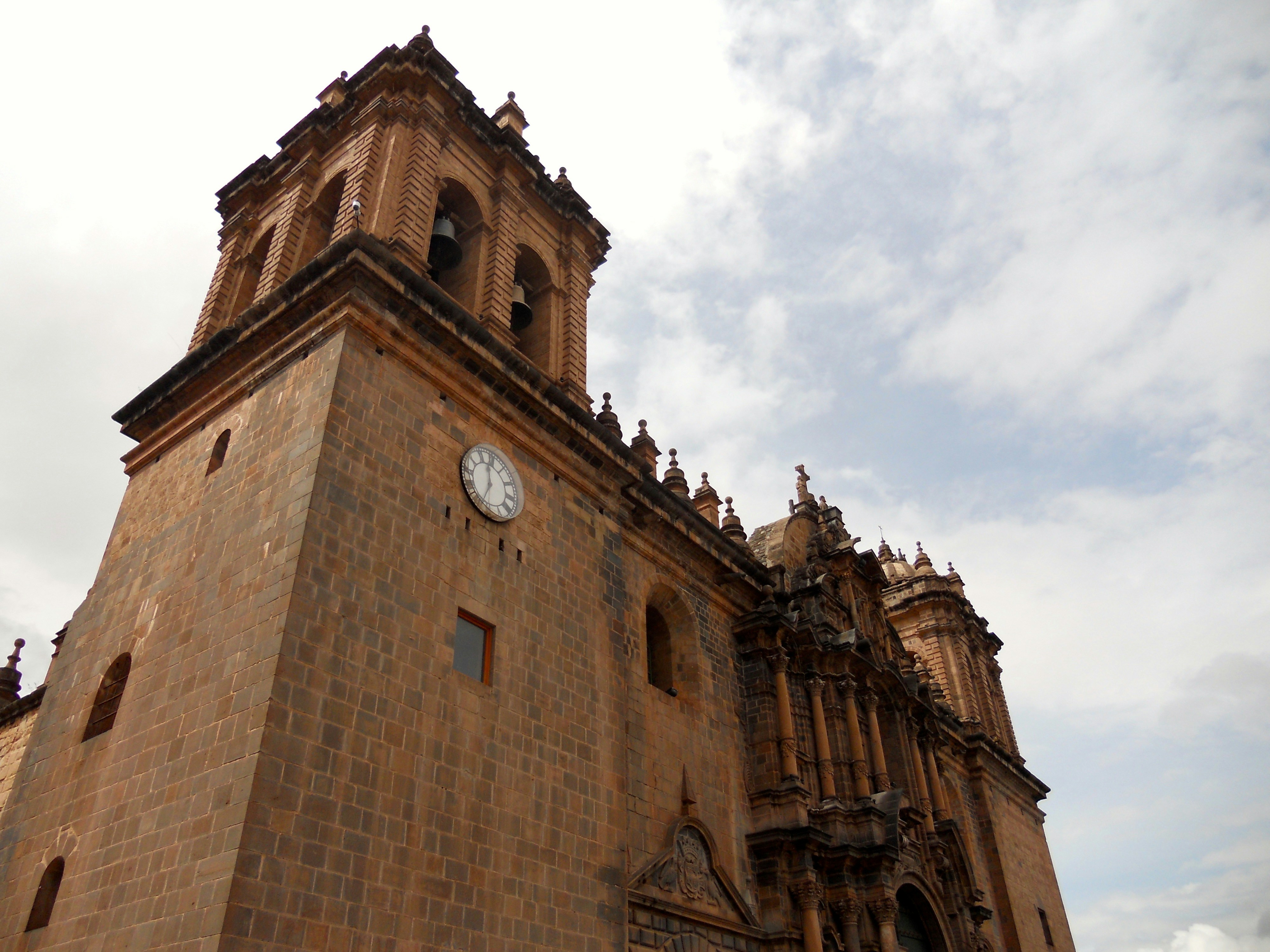 Un edificio alto con un reloj en el costado