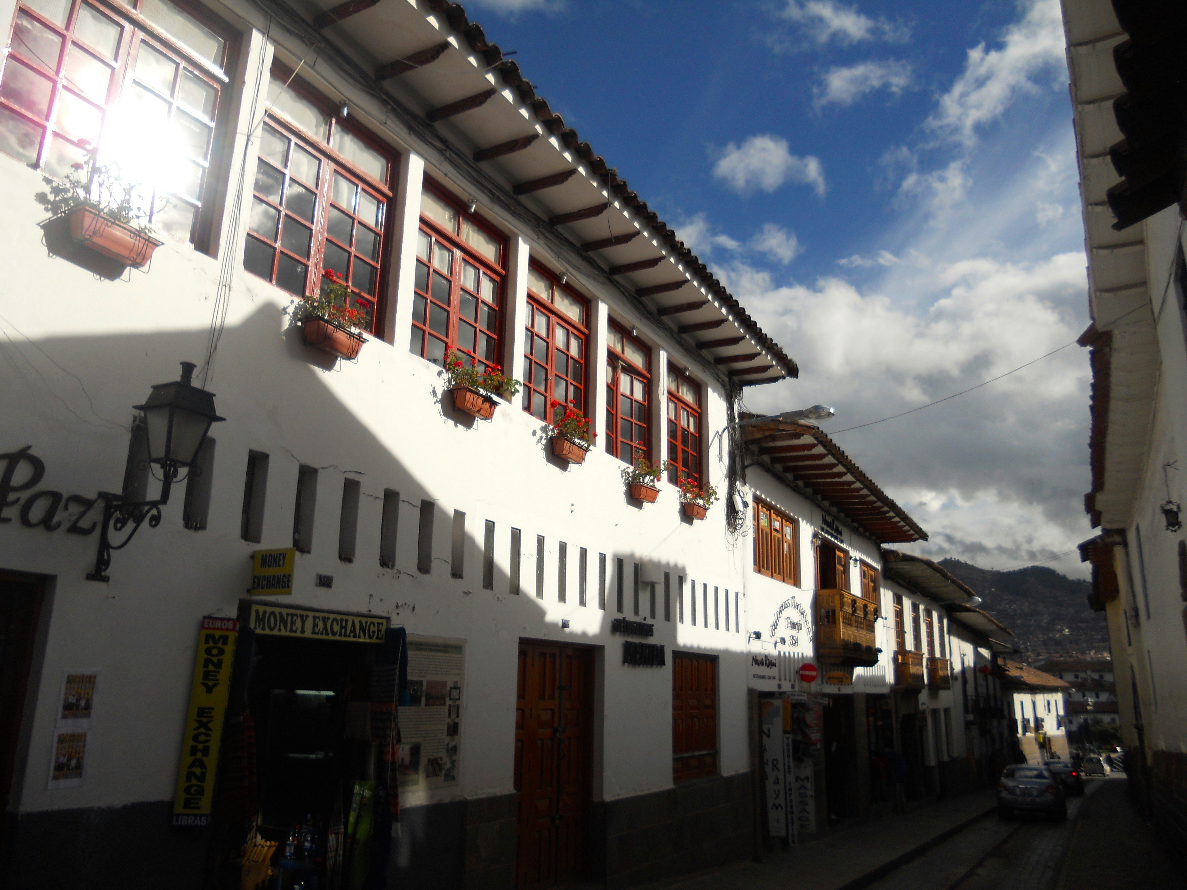 a white building with red windows and a sky background