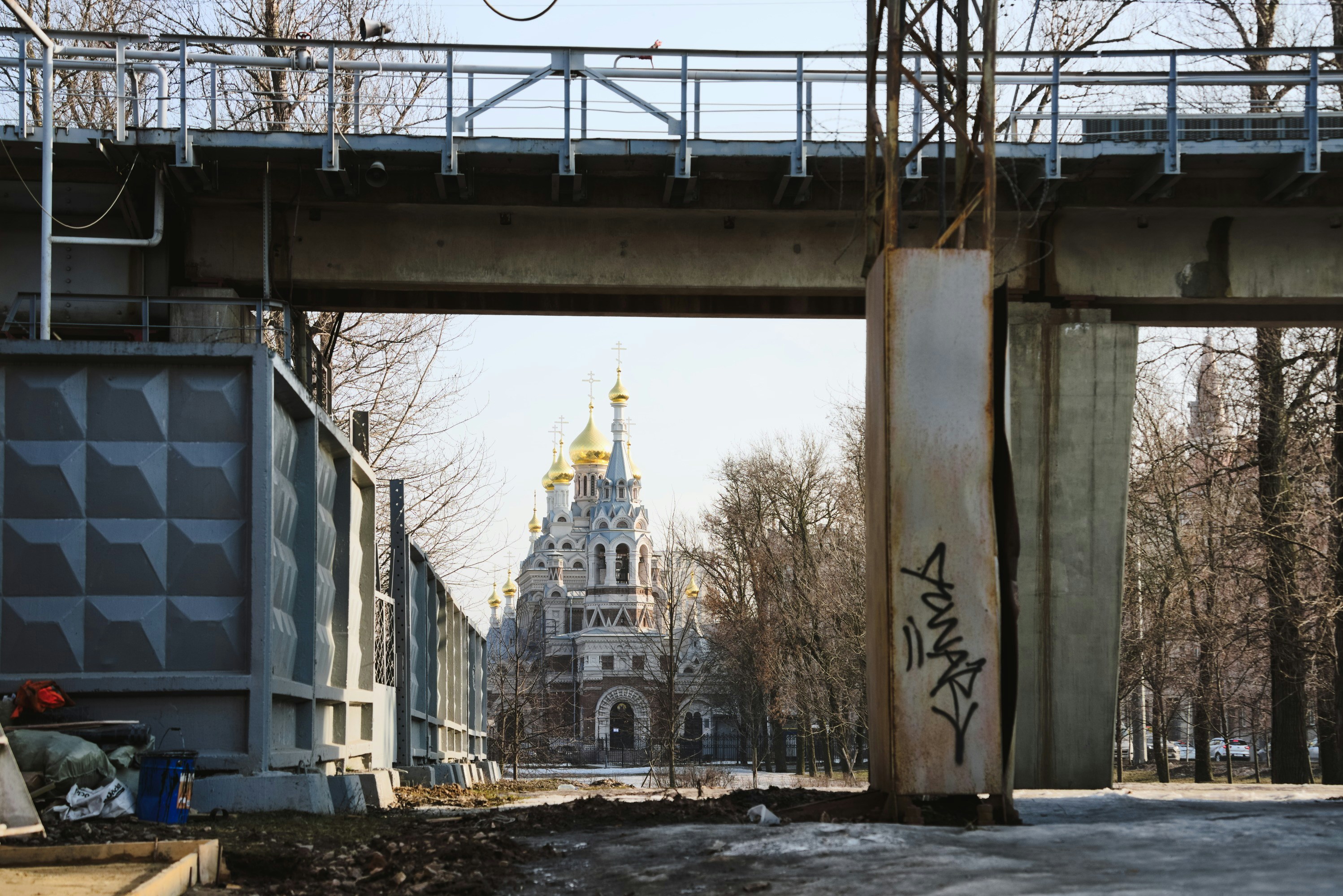 a bridge over a street with a church in the background