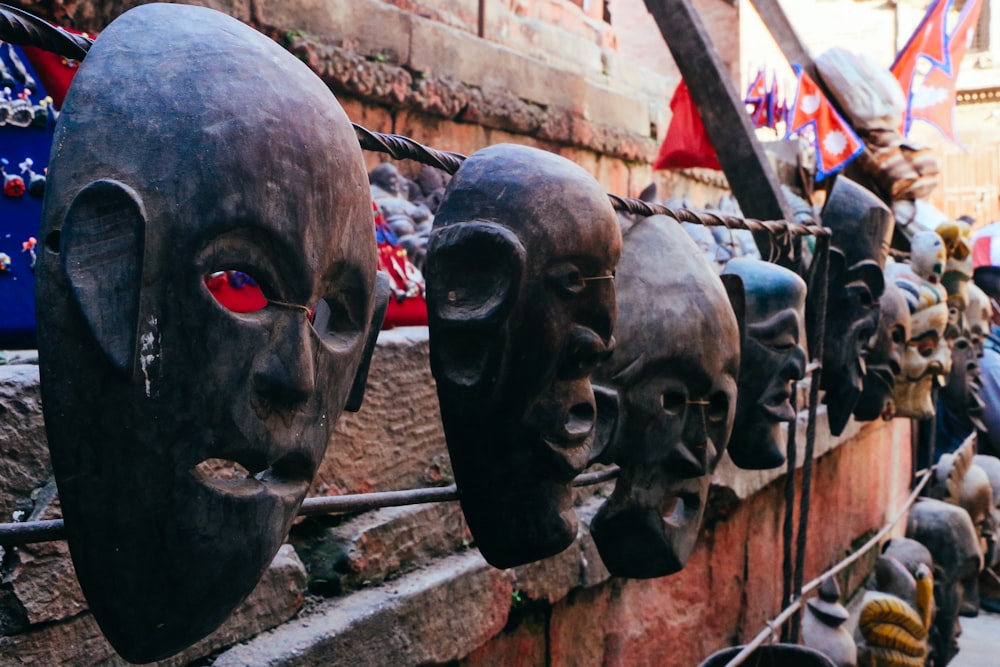 a bunch of masks are hanging on a wall