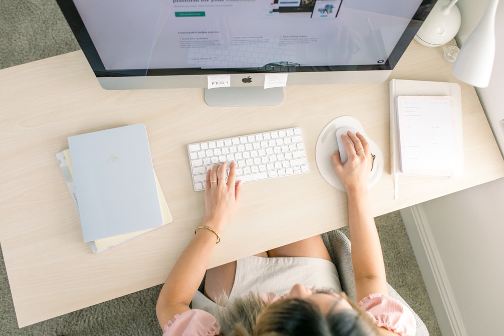 Une femme assise à un bureau avec un clavier et une souris