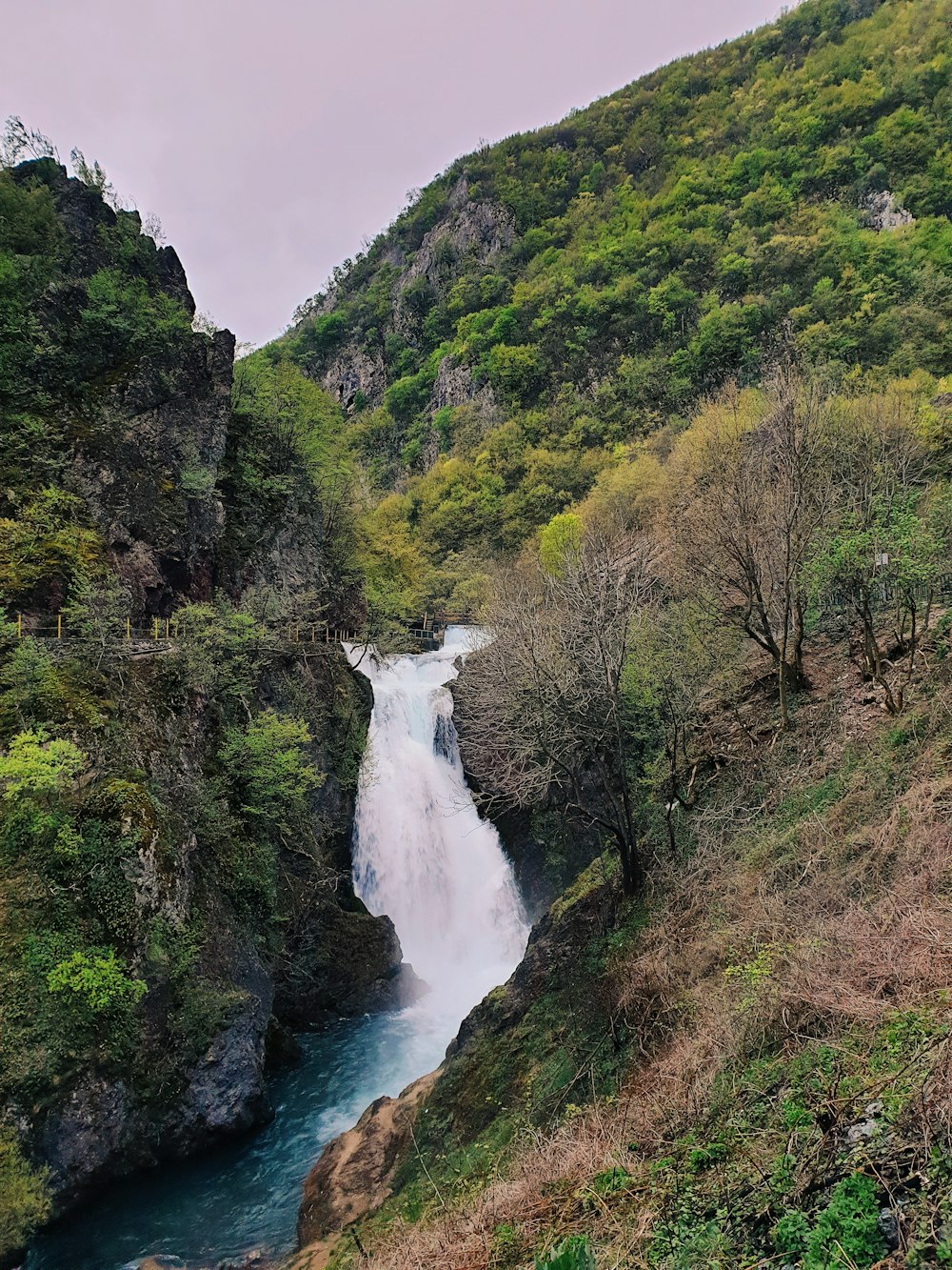 a river running through a lush green hillside