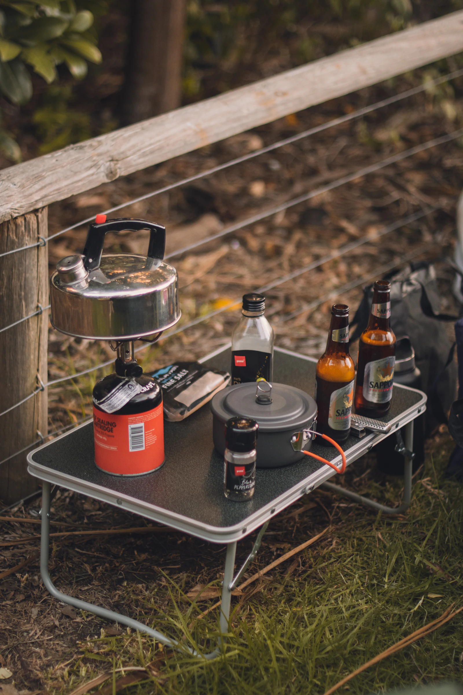 Camp cookware and stove equipment arranged on an outdoor table