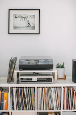 A minimalist black-and-white studio setup with vinyl records and a sleek turntable.