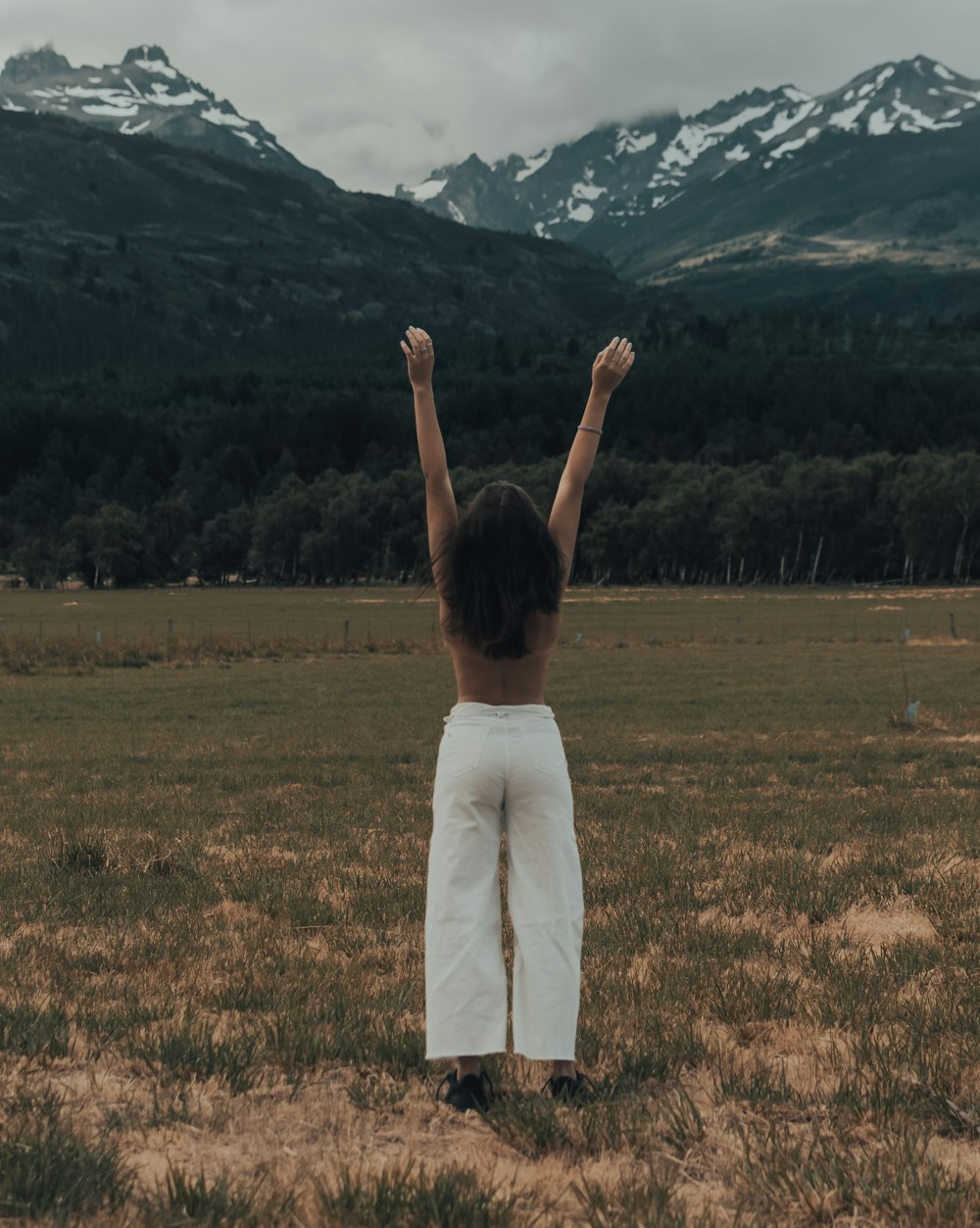 a woman standing in a field with her arms up