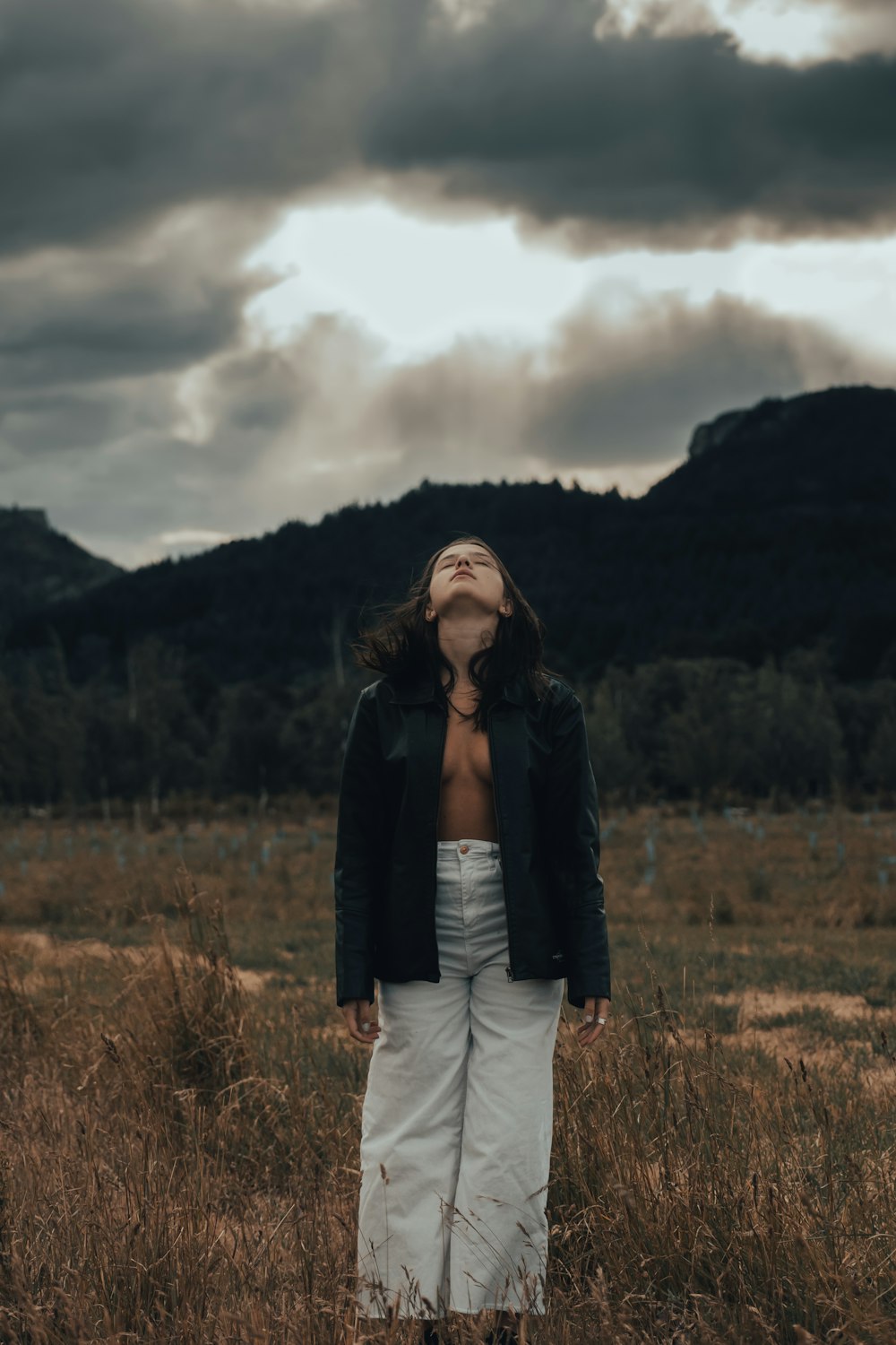 a woman standing in the middle of a field