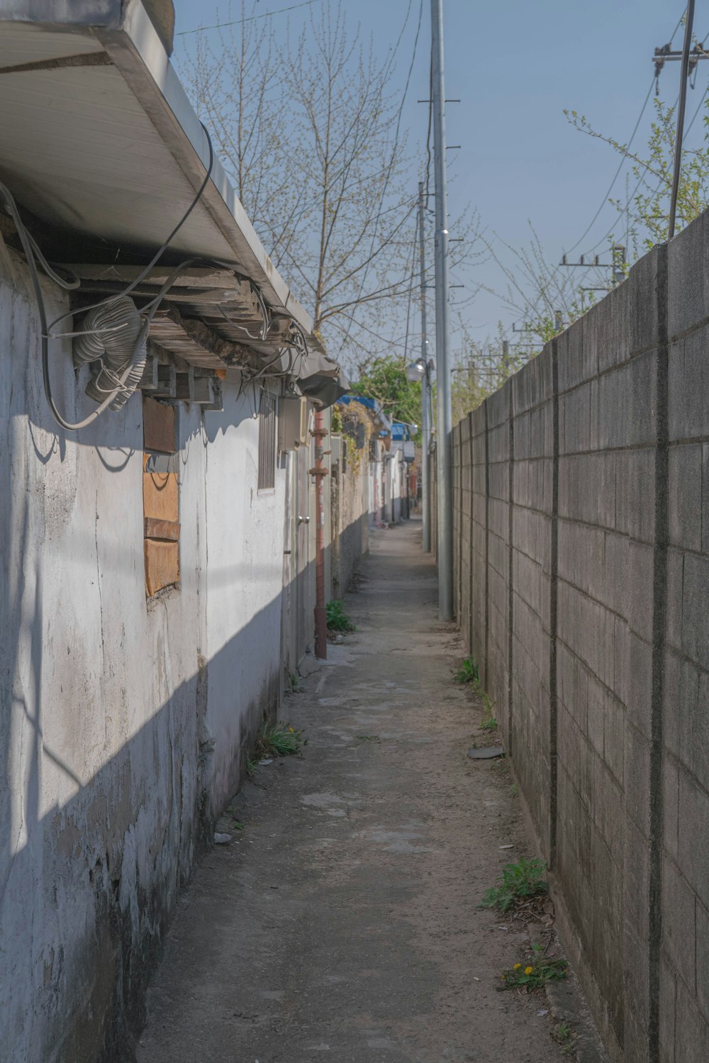 a narrow alley way with a telephone pole in the distance