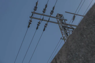 Close-up of a silicone polymer insulator installed on a high-voltage power line under a clear blue sky.
