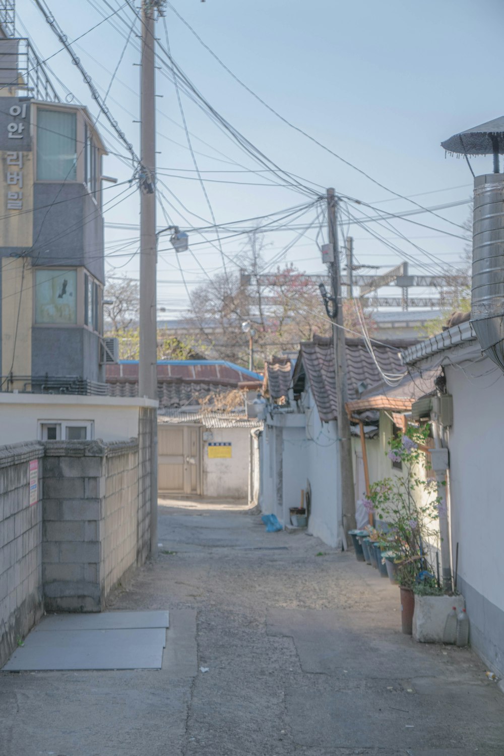 a narrow alley way with power lines above it