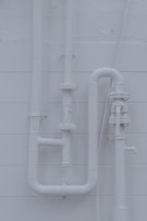 Detailed shot of plumbing pipes neatly aligned and secured inside a wall cavity.