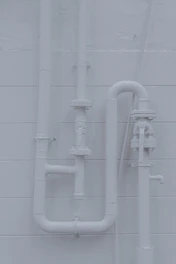 a white wall with pipes attached to it