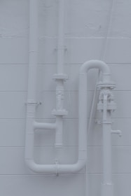 a white wall with pipes attached to it