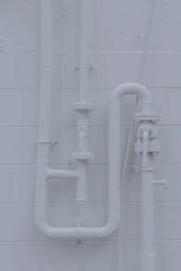 a white wall with pipes attached to it