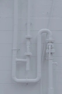 Finished plumbing work showing clean, organized pipes inside a commercial building wall