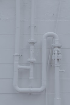 a white wall with pipes attached to it
