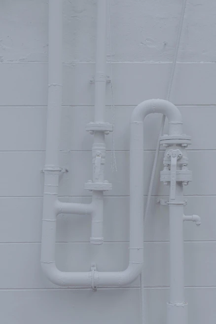 Neatly arranged pipes behind a bathroom wall showing expert craftsmanship and attention to detail