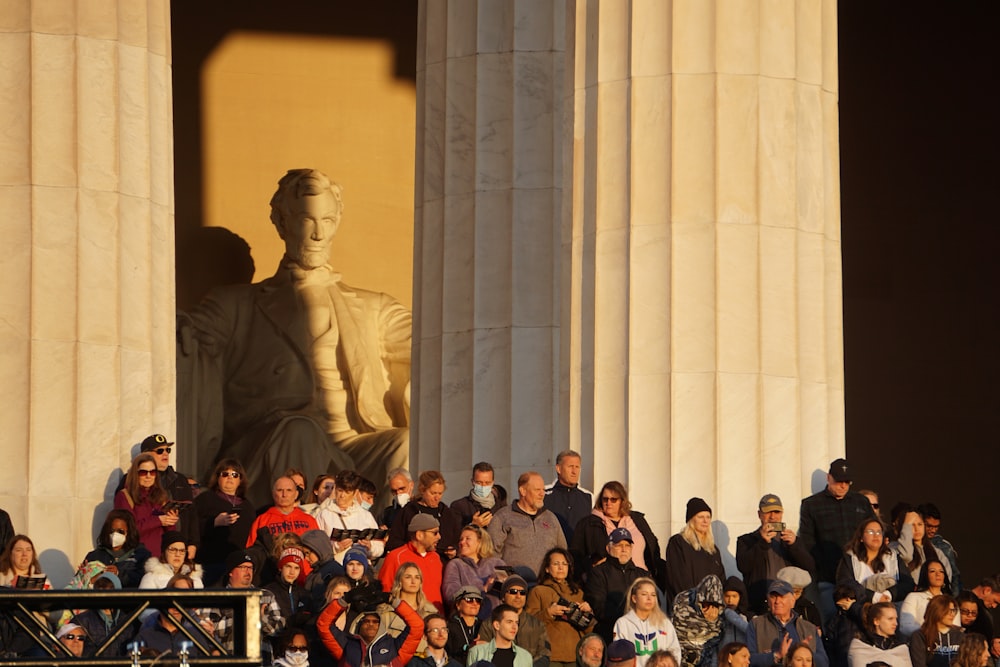 a crowd of people standing around a statue