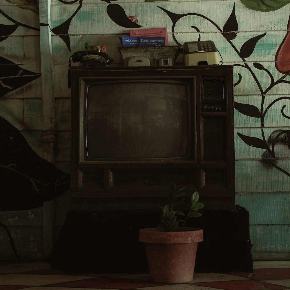 a small tv sitting on top of a wooden cabinet