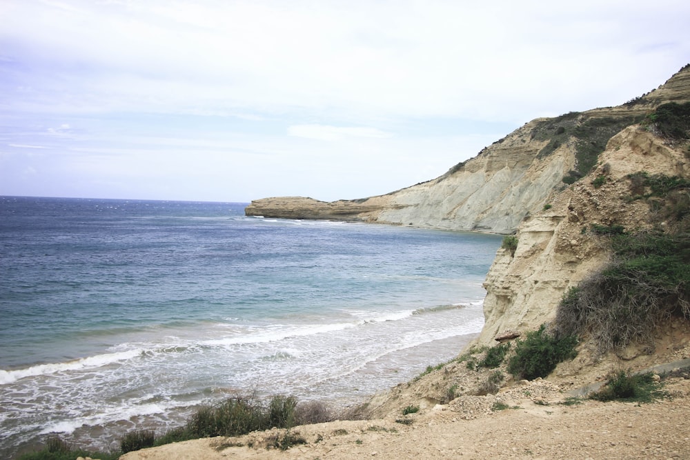 a rocky cliff overlooks a body of water