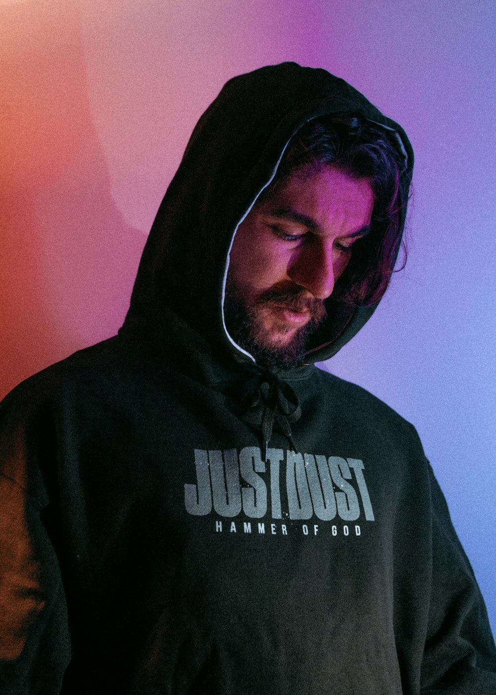 a man wearing a black hoodie with the word justhust on it