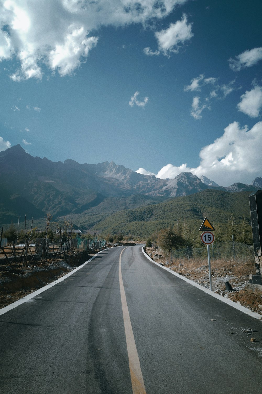 an empty road with mountains in the background
