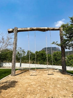 a wooden swing set in the middle of a field