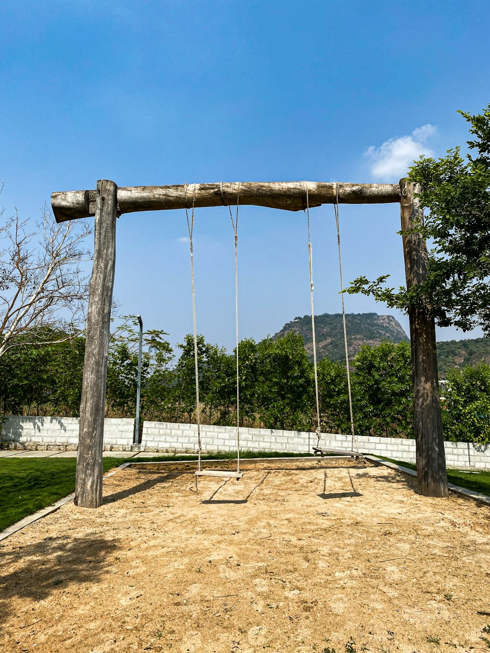 a wooden swing set in the middle of a field