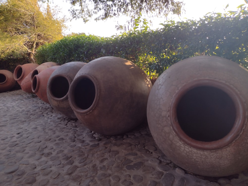 a row of clay pots sitting on top of a sandy ground