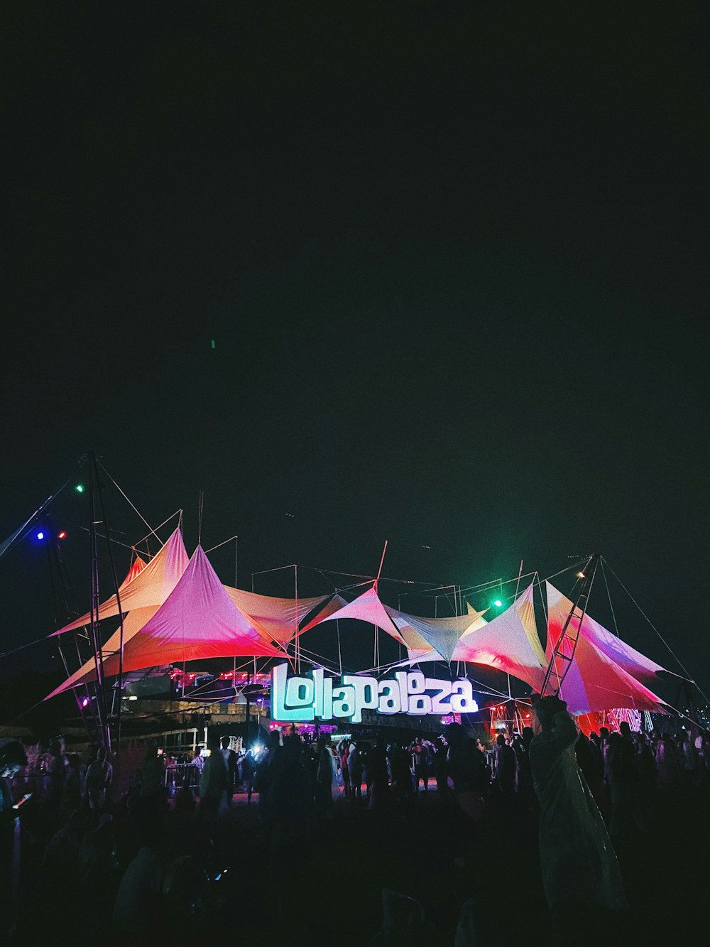 a crowd of people standing around a tent at night