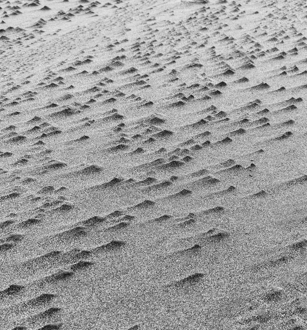 a black and white photo of footprints in the sand