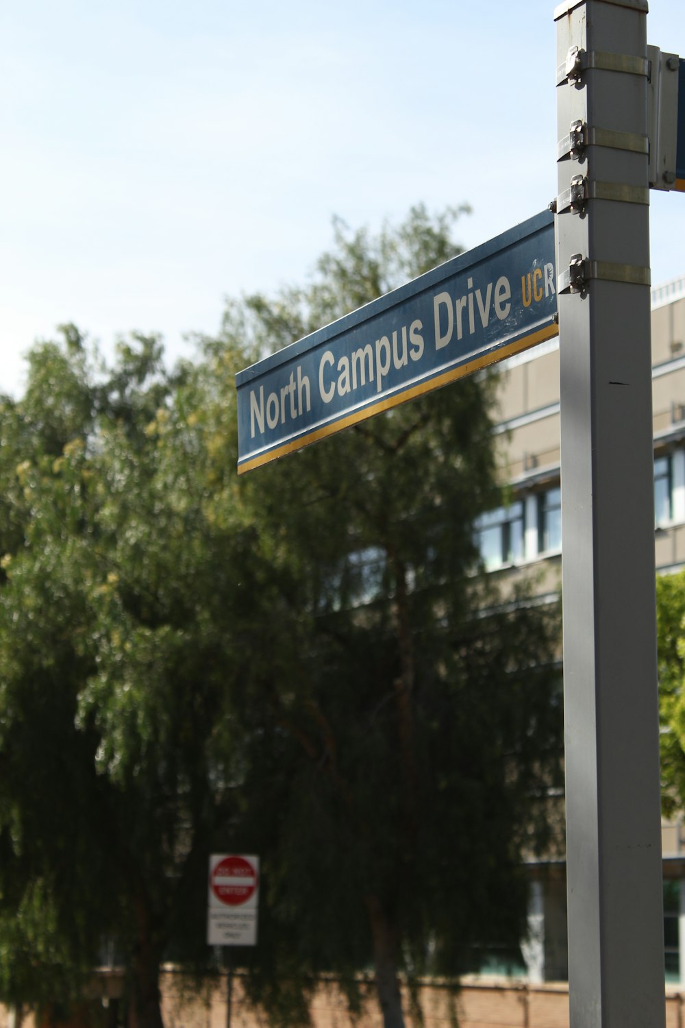 a street sign for north campus drive in front of a building