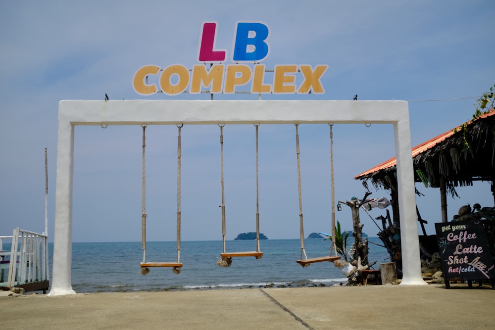 a sign that reads, l b complex with swings in front of it