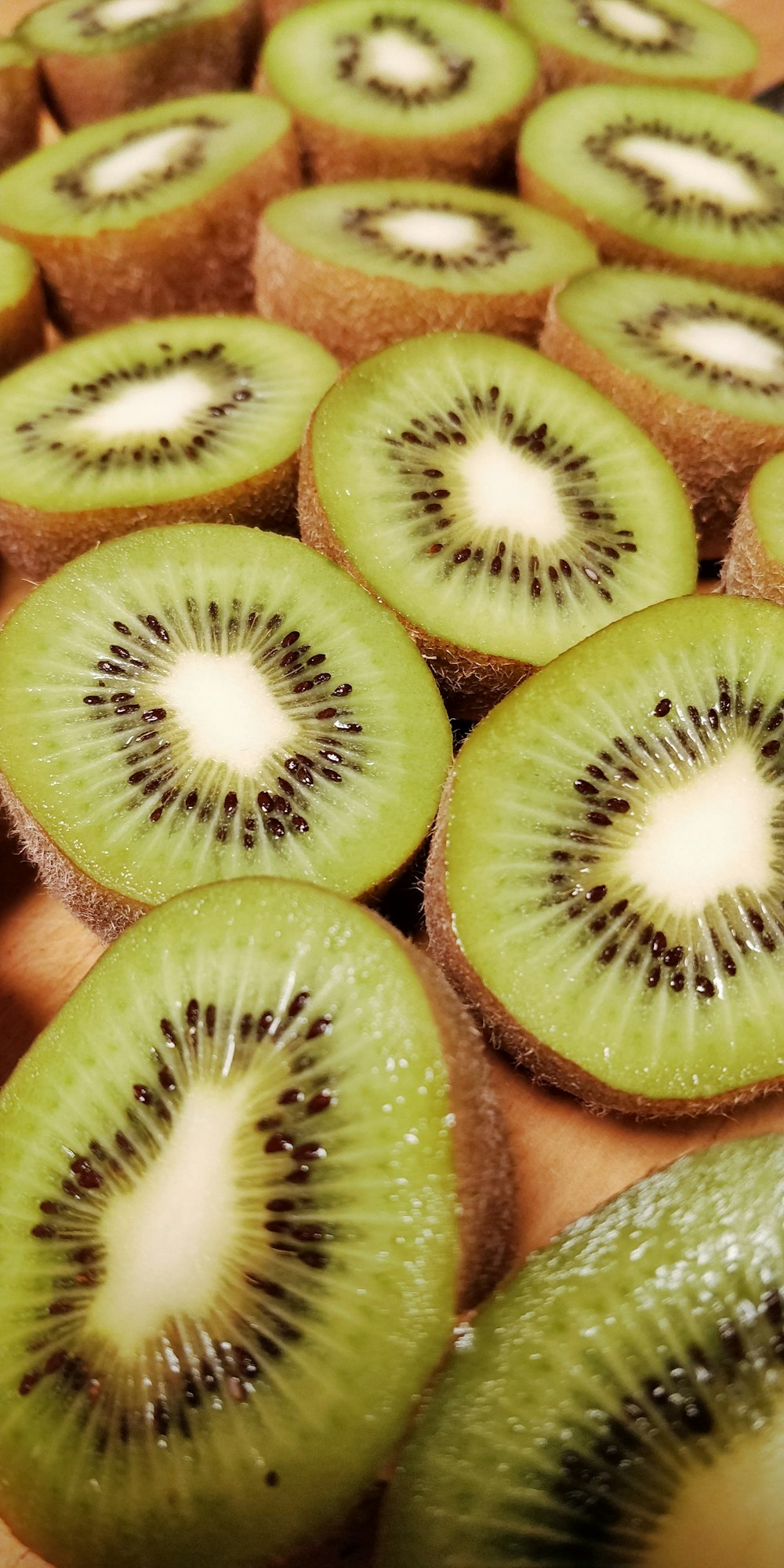 a bunch of kiwi cut in half on a cutting board