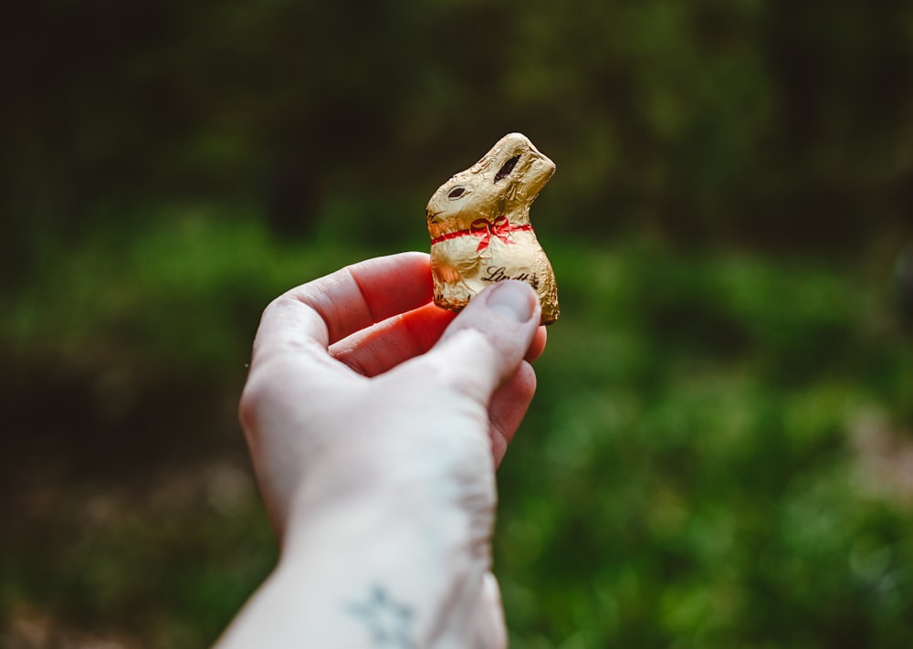 a person holding a small toy animal in their hand
