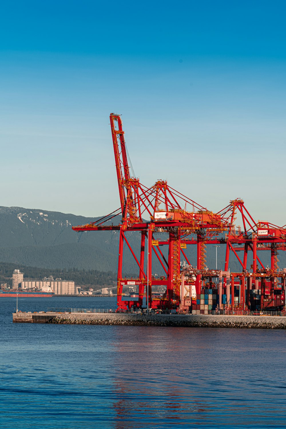 a large red crane sitting on top of a body of water