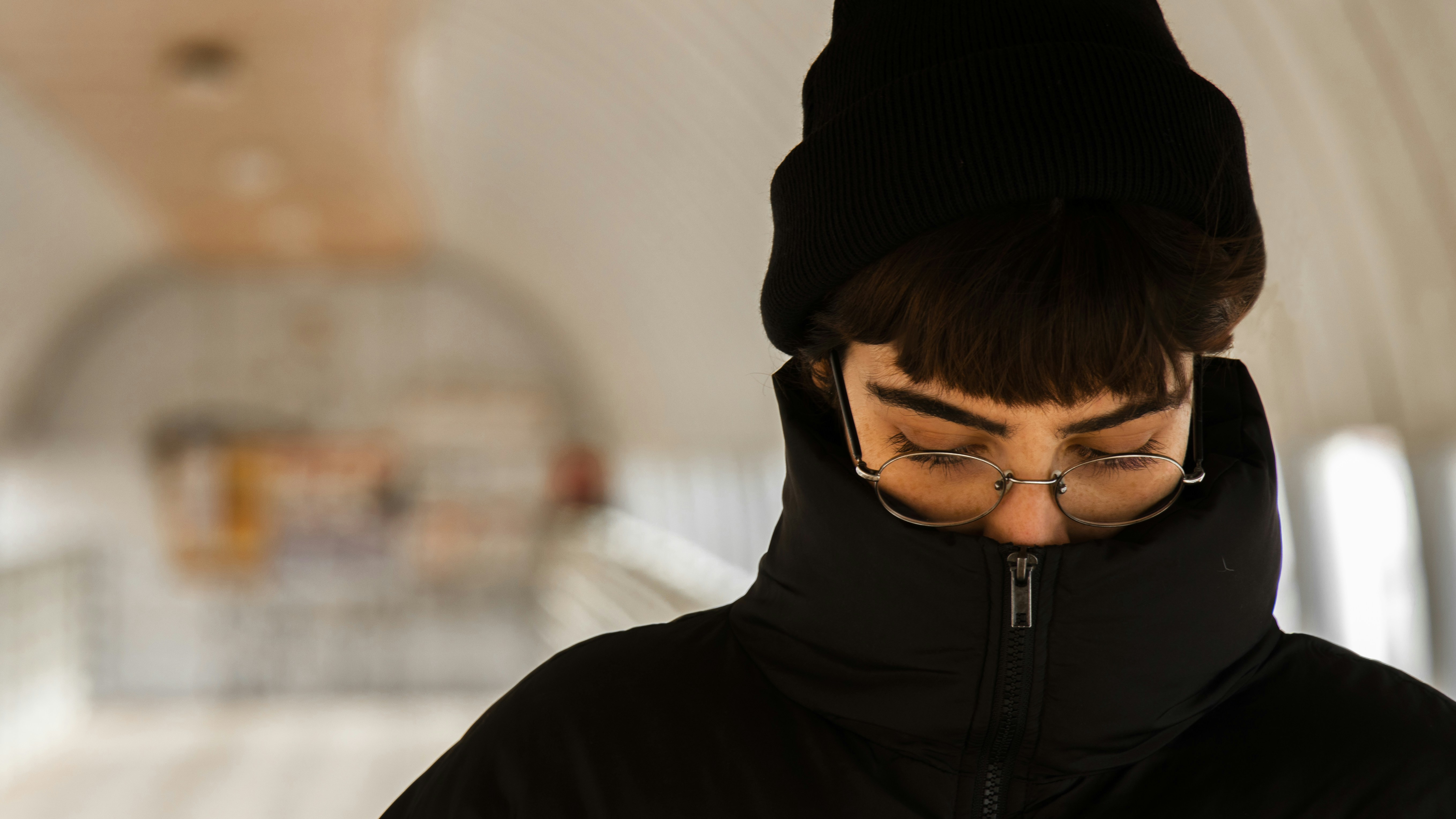 a man wearing glasses and a black hat