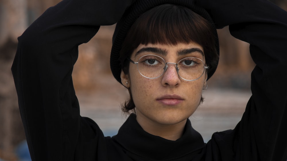 a woman wearing glasses and a black shirt