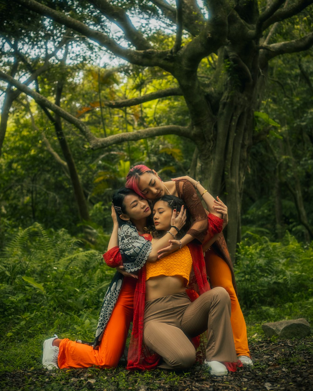 a group of women hugging each other in a forest