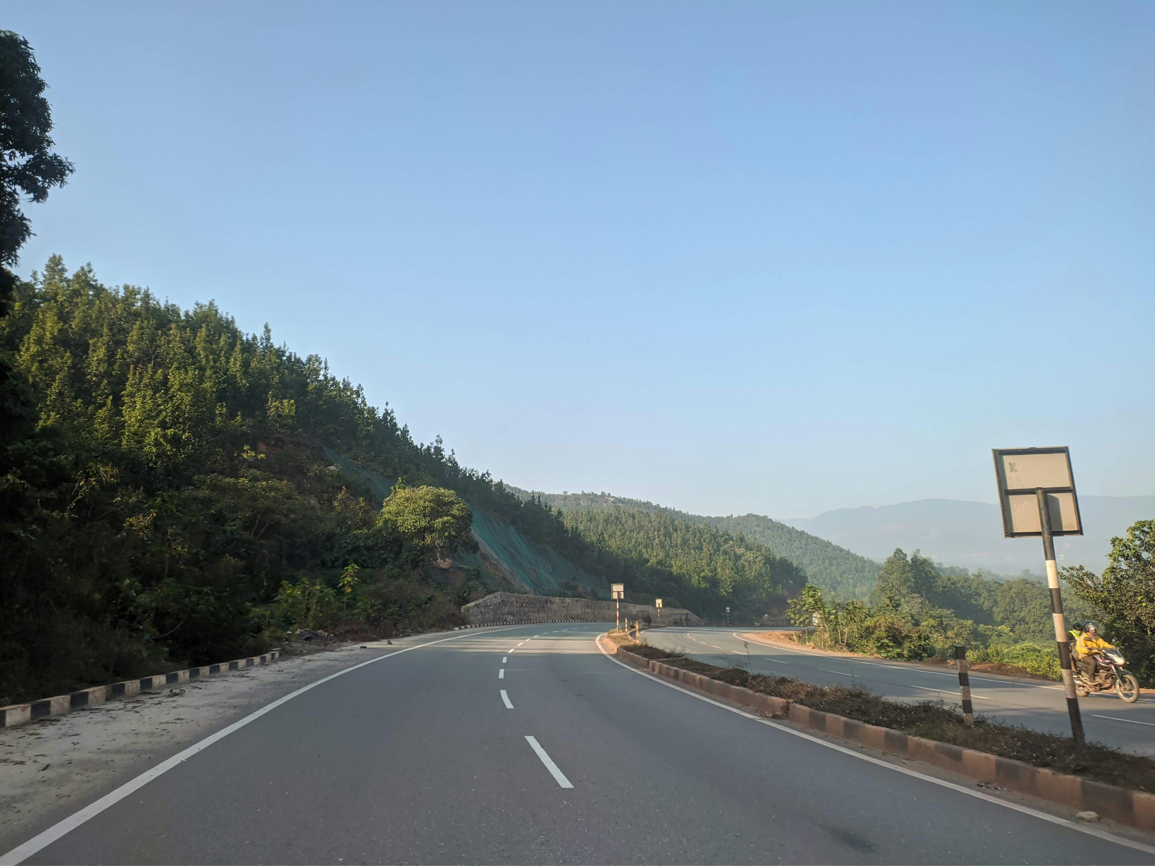 an empty road with a sign on the side of it