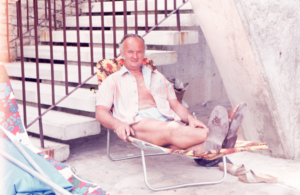 a man sitting in a chair next to a stair case