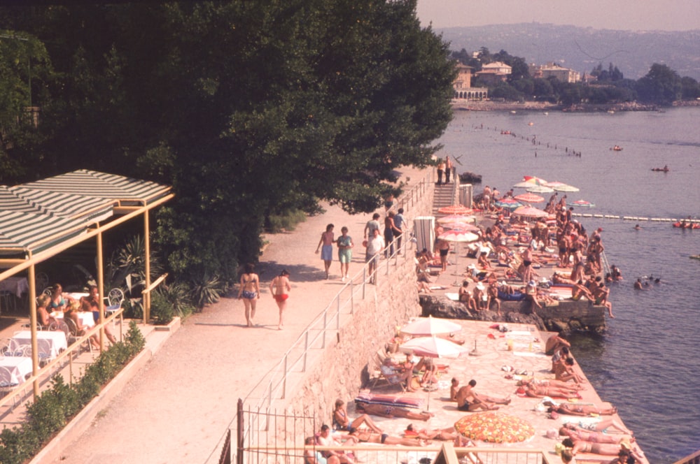 a group of people on a beach next to a body of water