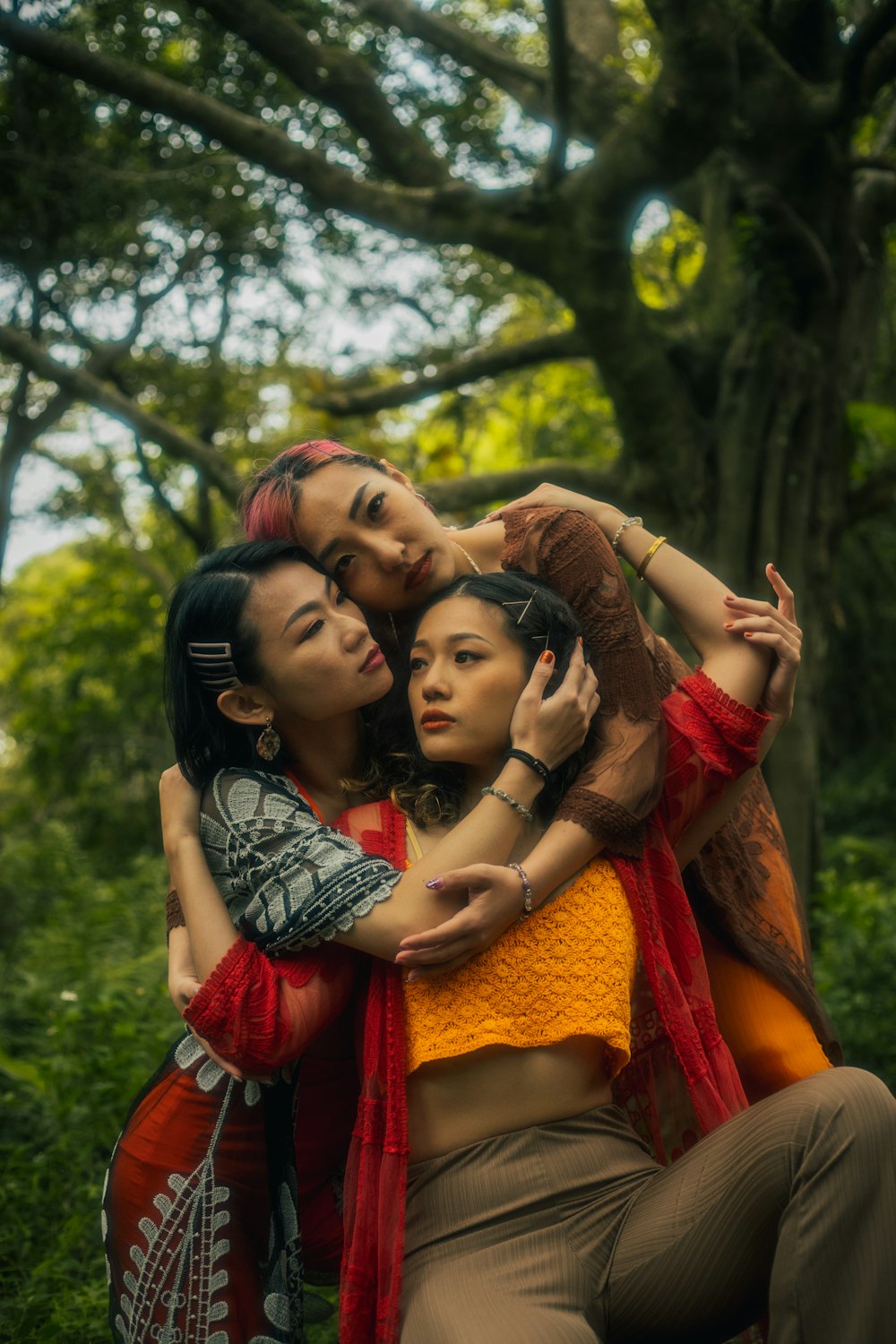 a group of women hugging each other in a forest