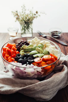a glass bowl filled with different types of vegetables