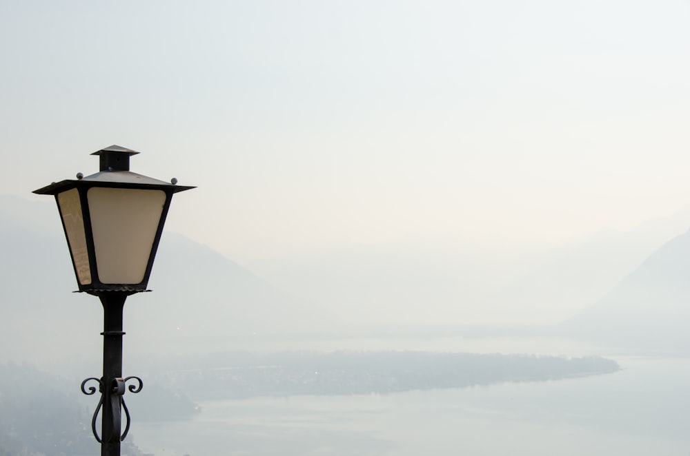 a lamp post with a lake in the background